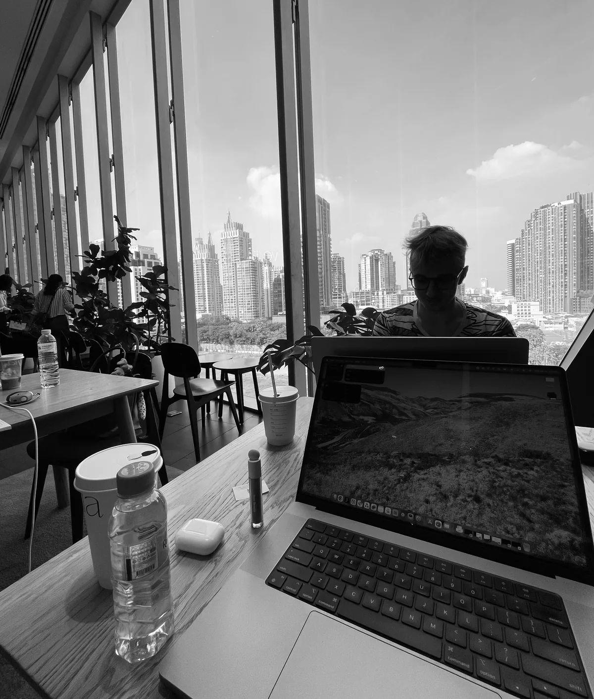 A desk by a window with an open laptop, looking out over a city skyline