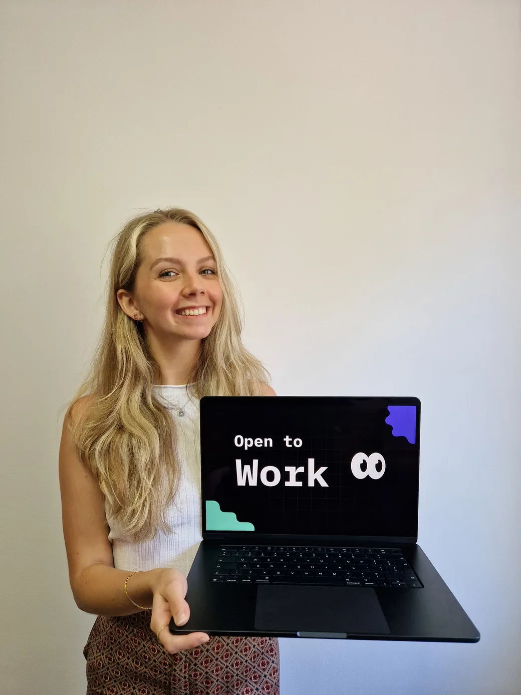 Viviana Homan holding an open laptop whose screen reads Open to Work
